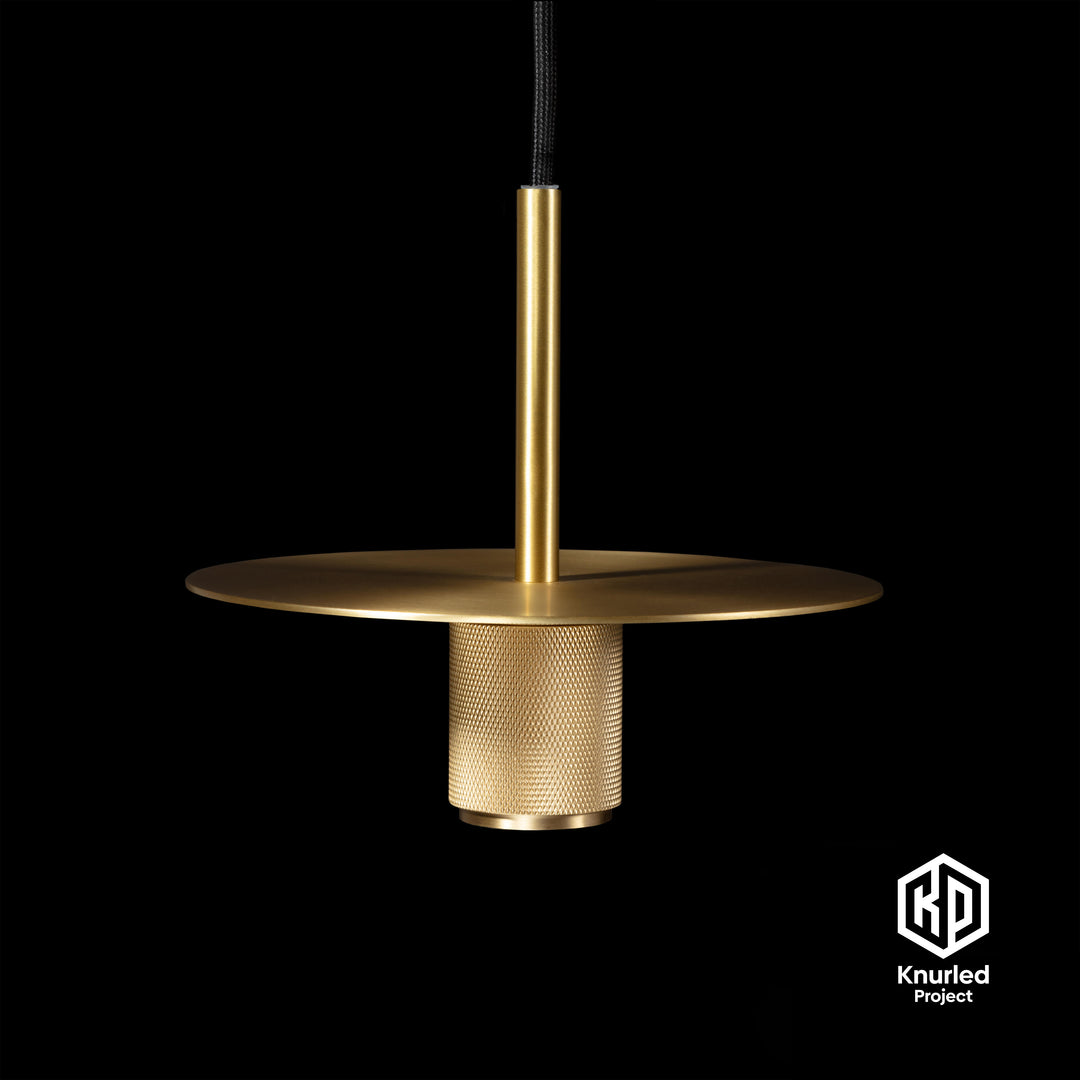 Brass pendant light hanging from a light chord