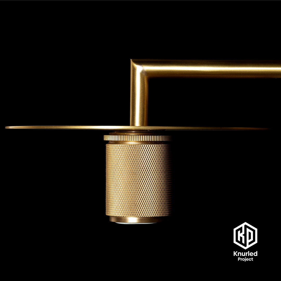 Brass wall light zoomed in to show the disc with diamond cut finish too on a black background