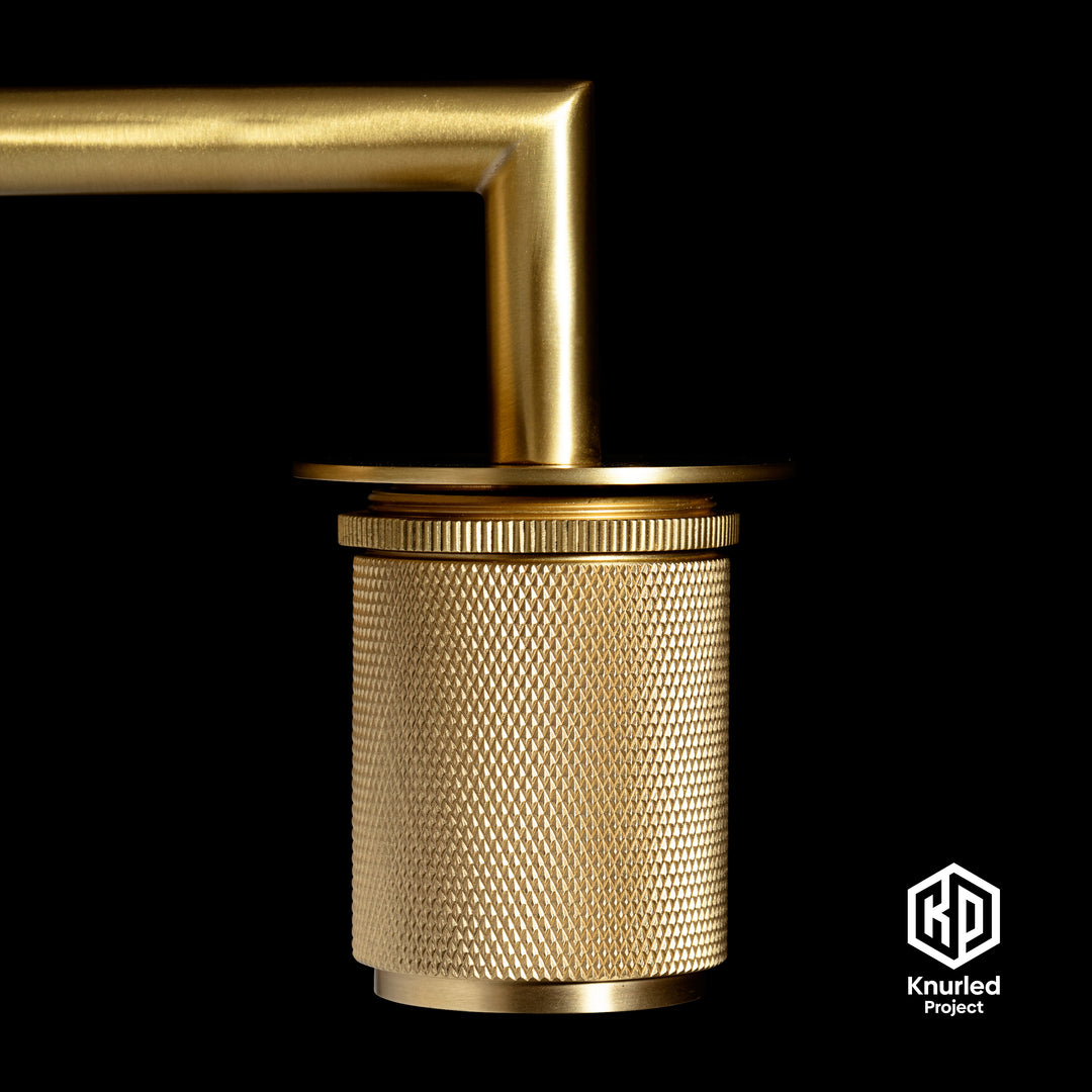 Brass wall light zoomed in to show diamond cut and knurled finish on a black background