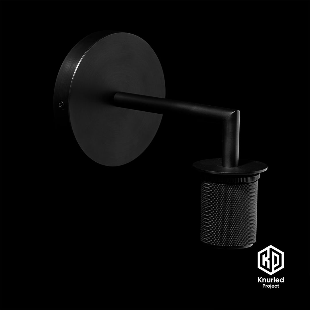 Matte black brass wall light at an angle