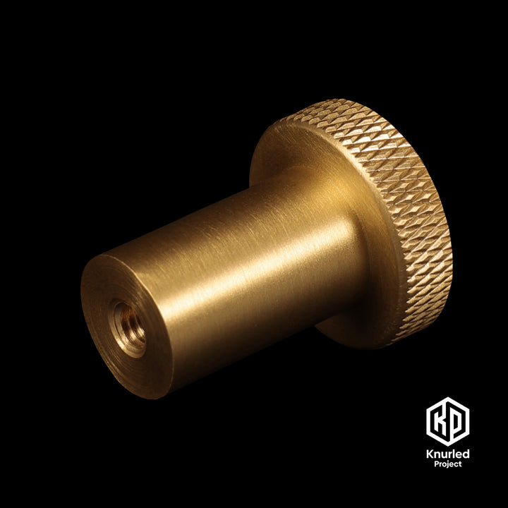 Brass mushroom button handle on a black background