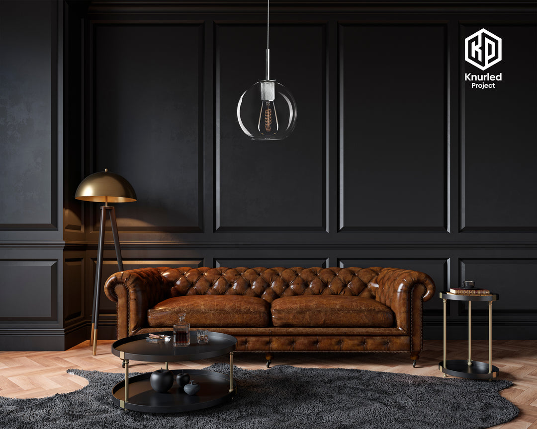 Chrome pendant light with filament bulb and a globe shaped light shade, hanging from a light chord  in a living room